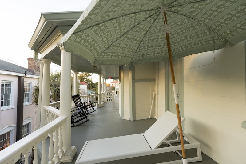 beach chairs with umbrellas outside on the veranda of room 301